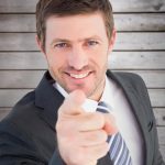 composite-image-of-businessman-smiling-and-pointing